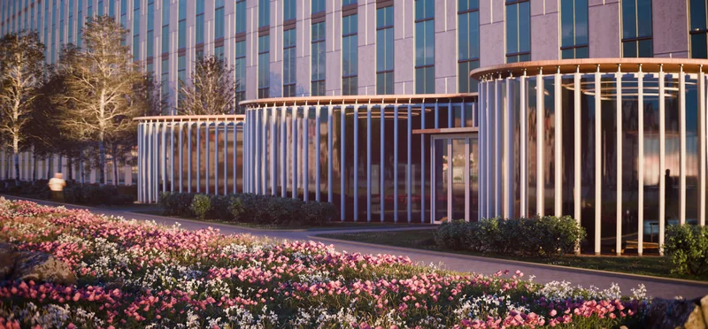 A modern building behind a field of flowers at dusk